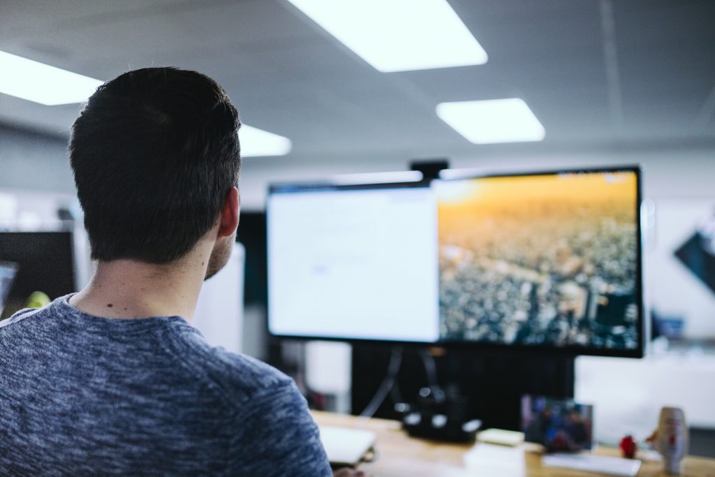 Man looking at computer monitors