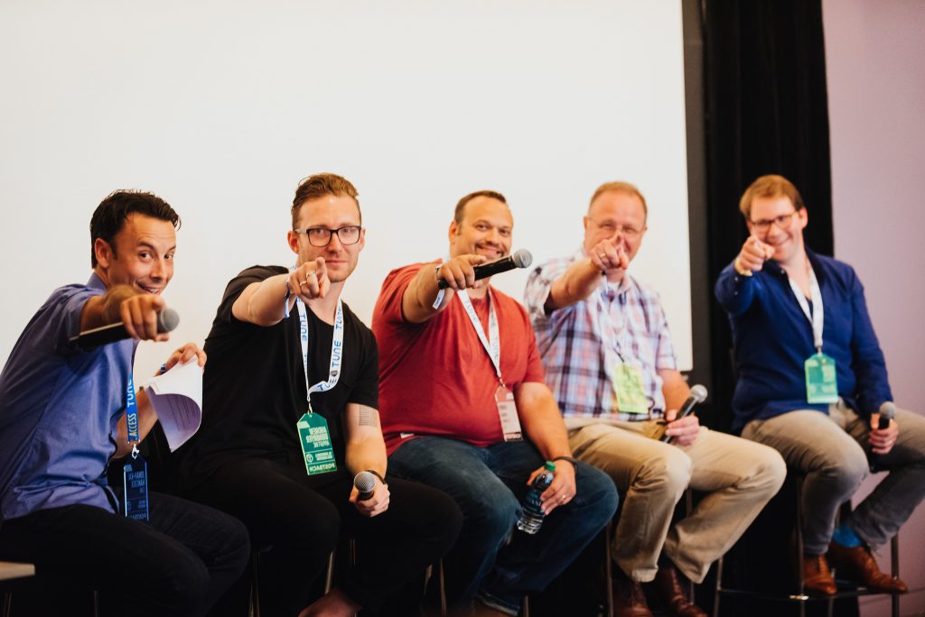 Presenters point their microphones at the camera during a break