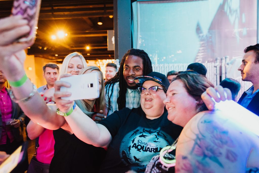 Richard Sherman poses with fans at a music event during Postback 2016
