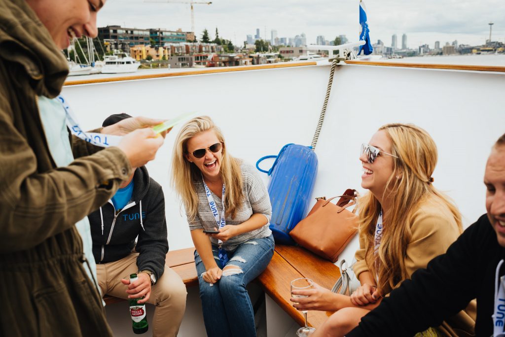 TUNE marketers laugh on a boat ride on Lake Washington