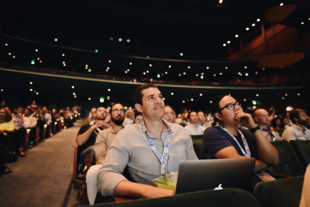 Audience members watch the main stage in the auditorium at Postback 2016