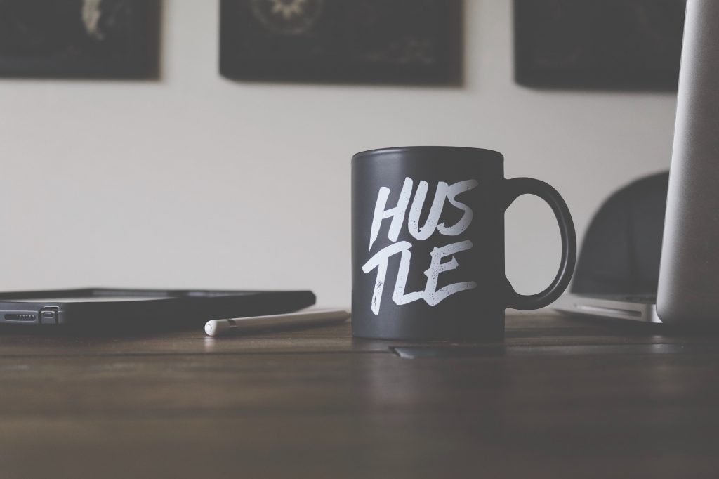 Performance marketing mug with "Hustle" logo.
