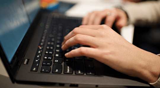 Image of man's hands on a computer