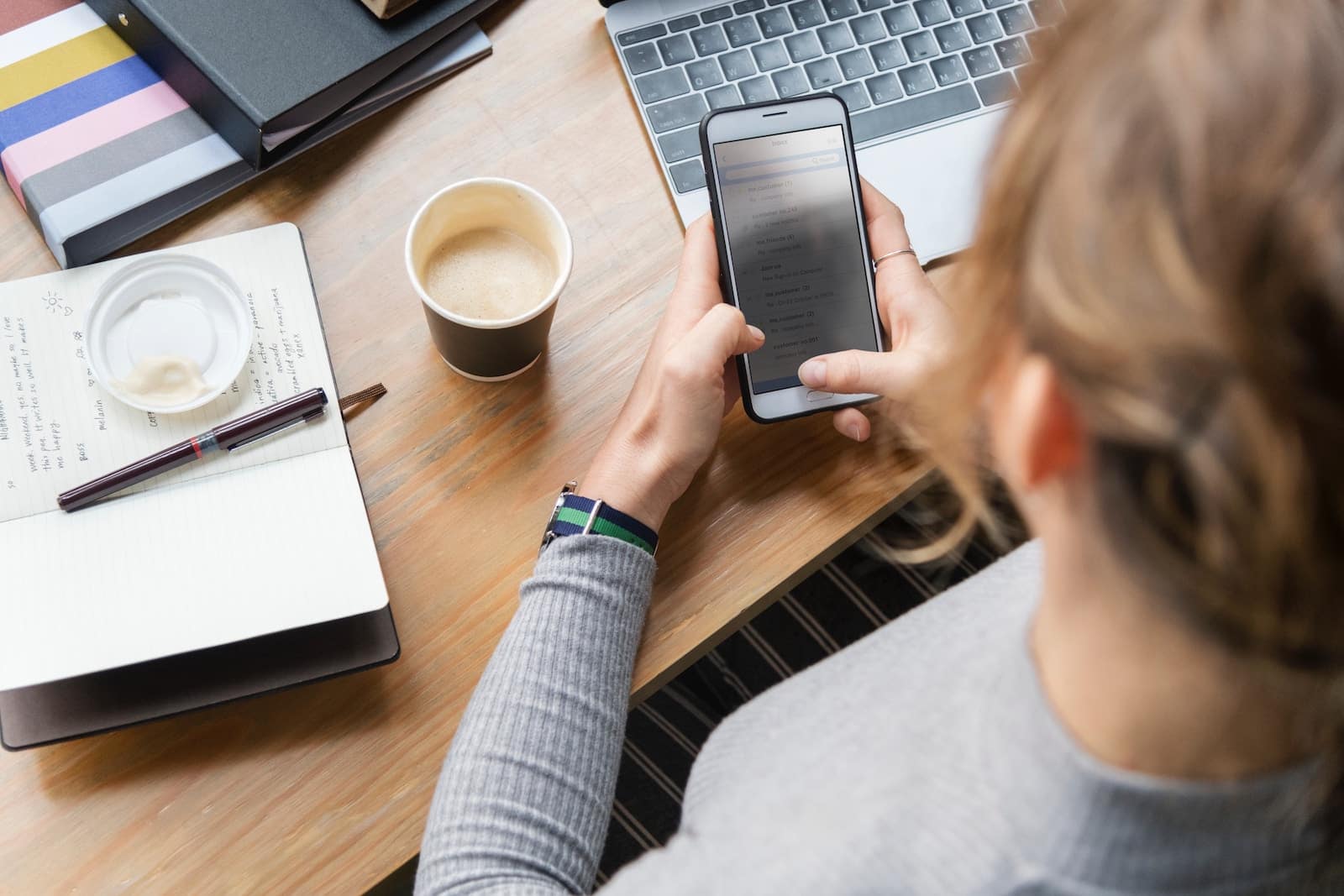 A media buyer answers emails on her mobile phone as she plans her marketing goals for the day.