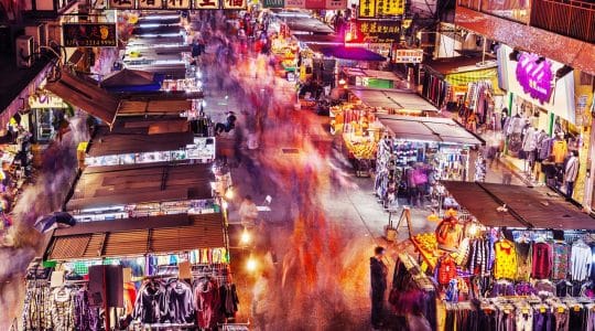 A bustling street of neon stores shows the staying power of physical locations in retail.