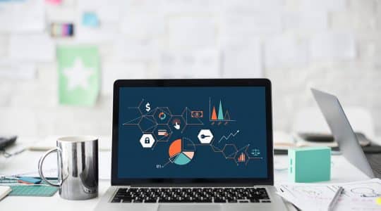 A computer with graphs and charts represents performance marketing.