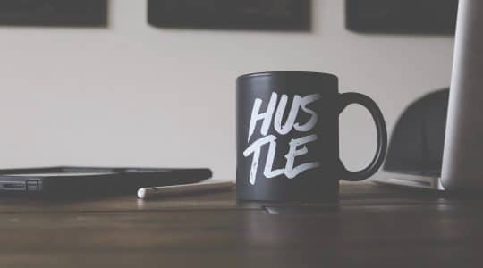 Mug in marketing office that reads "Hustle."
