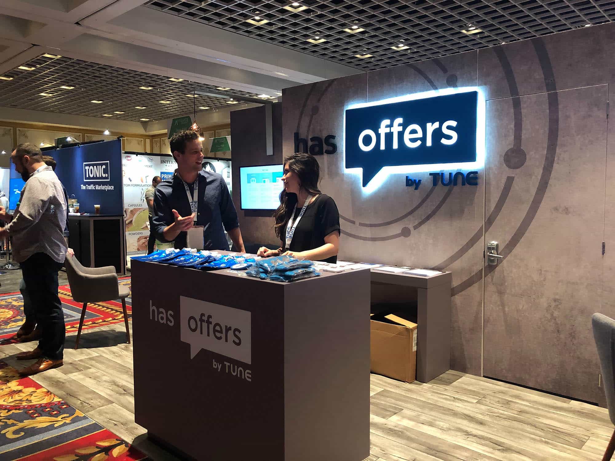 Two HasOffers reps chat in their booth at Affiliate Summit West 2019