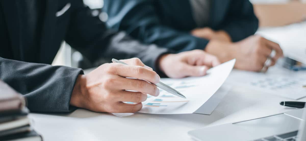 Closeup of hands and paper in meeting for the Credit Sesame TUNE case study