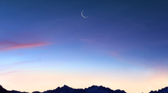 Crescent moon over mountains