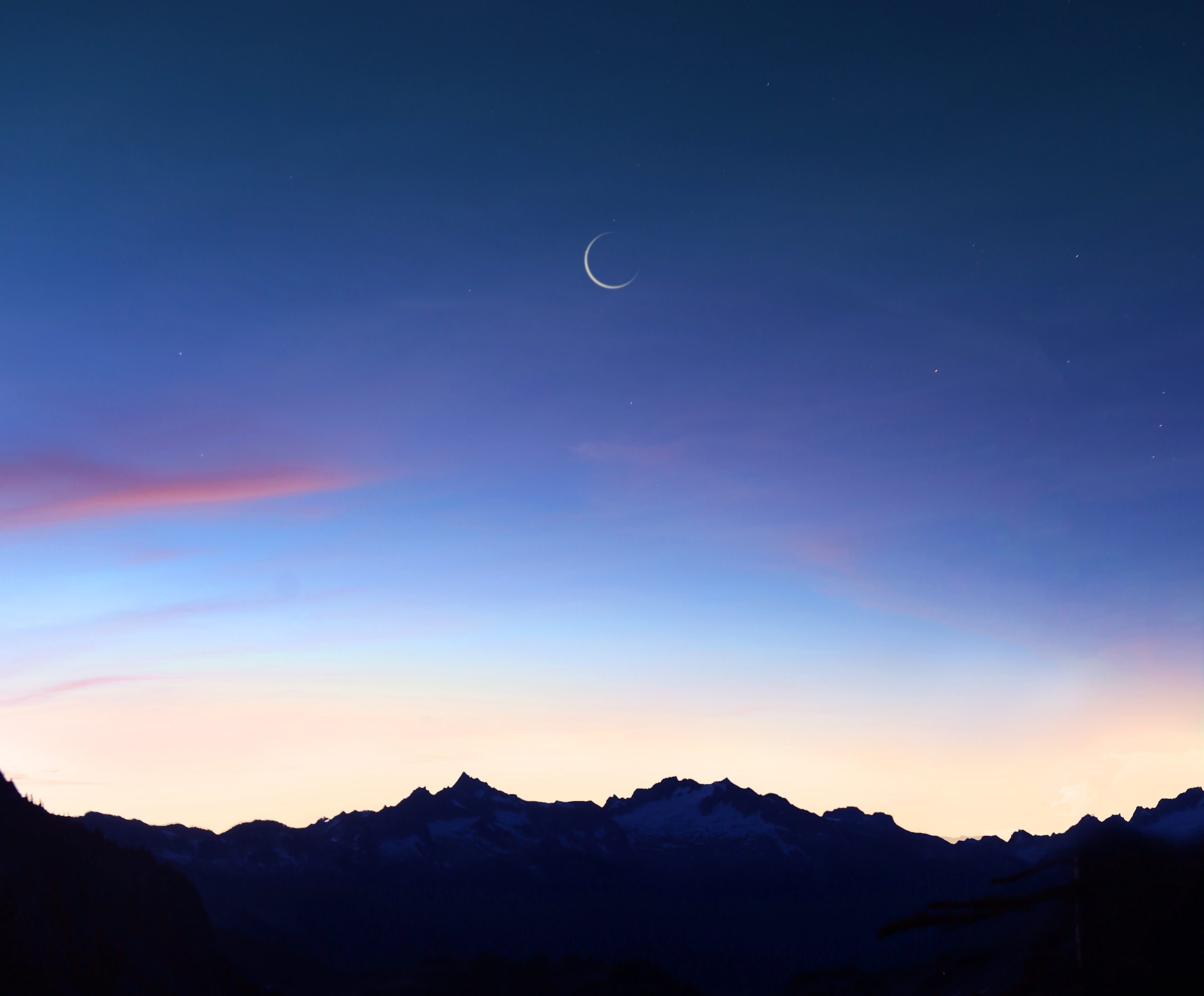 Crescent moon over mountains