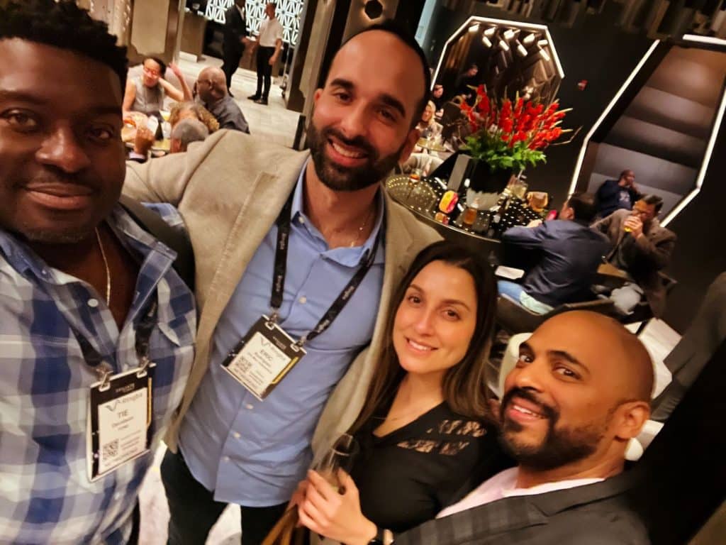 Tie and some guests smile for the camera during the Network and Chill Happy Hour at ASE 2022.