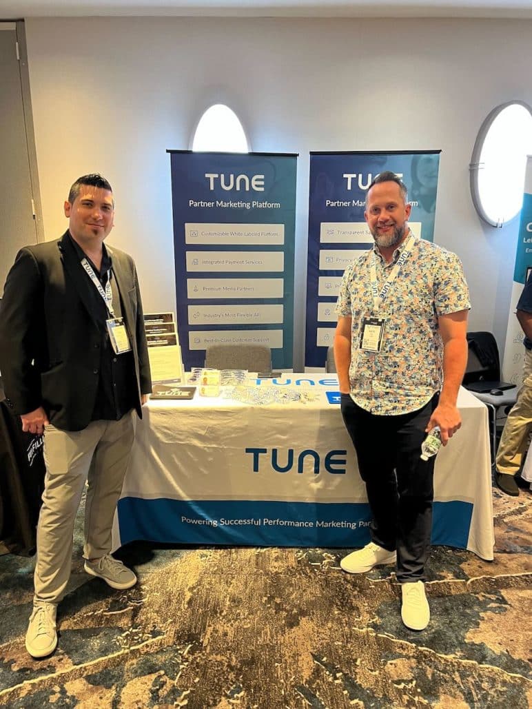 Dan and Nate in front of TUNE's Meet Market Table at Affiliate Summit East 2022.