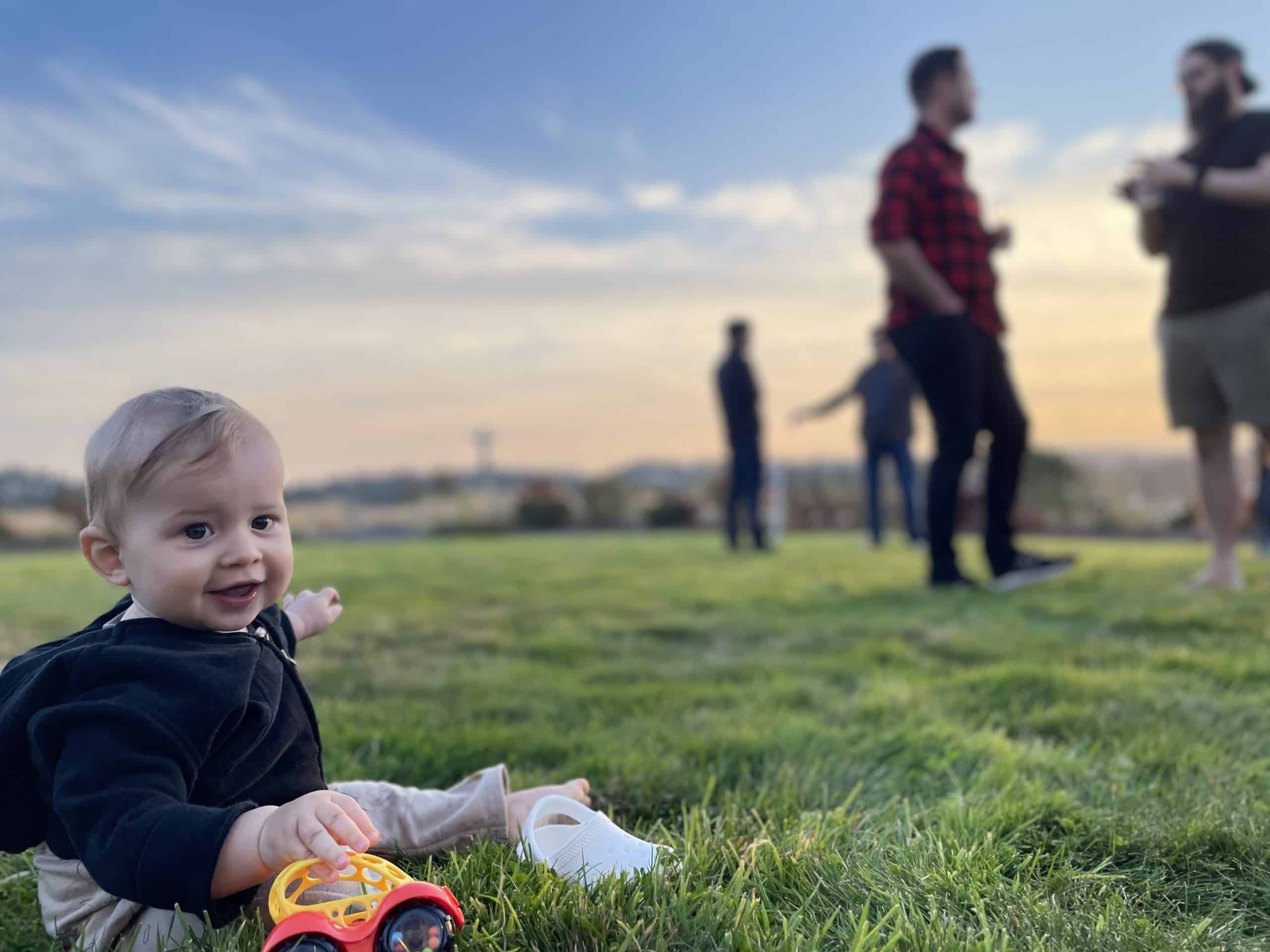 Baby Mercer plays in the grass during the 2022 TUNE retreat